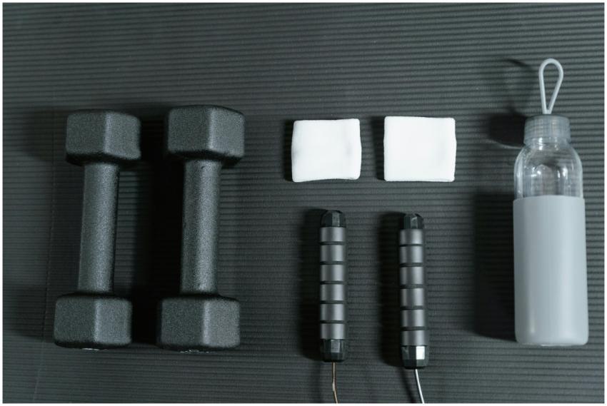 Flat lay of dumbbells, jump rope, and other gym es