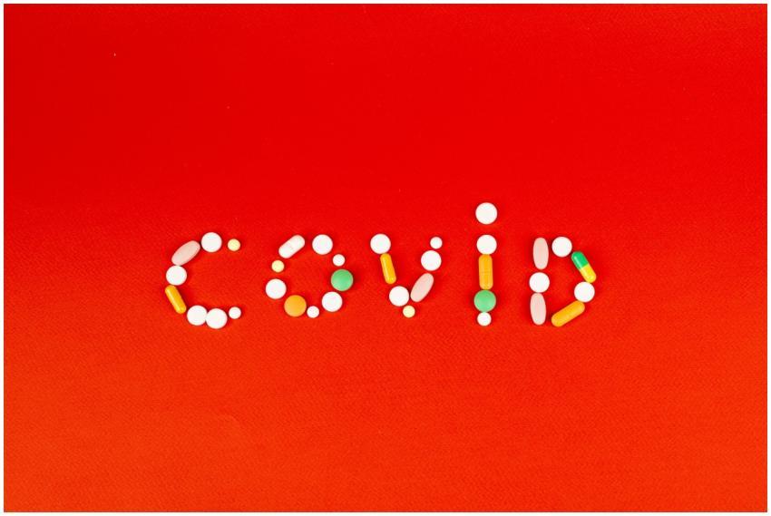 COVID spelled using assorted pills on a vibrant re