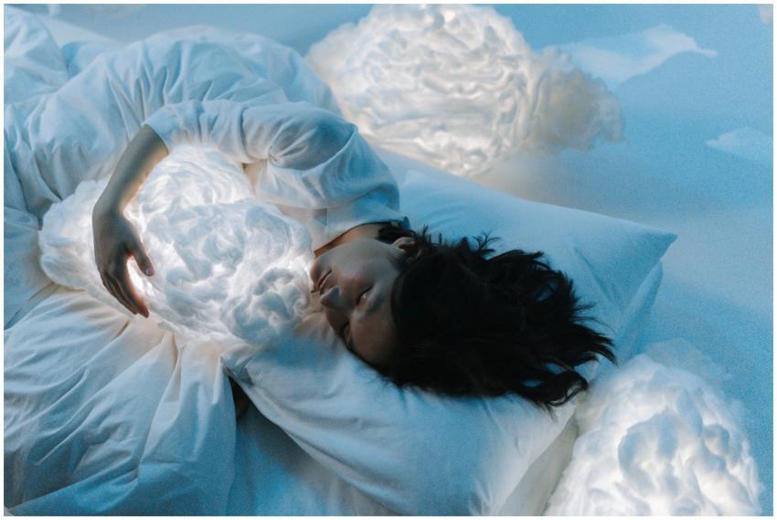 Woman in white hugging glowing cloud pillows in se