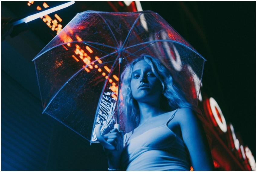 Portrait of a woman under umbrella with neon light