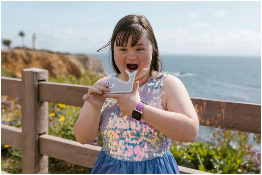 A joyful girl with Down Syndrome holding a whale t