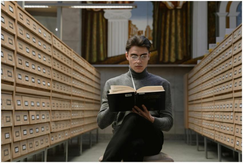 A young man reads a book in a modern library archi