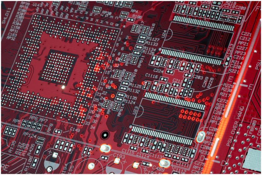 Detailed shot of a red motherboard showcasing elec