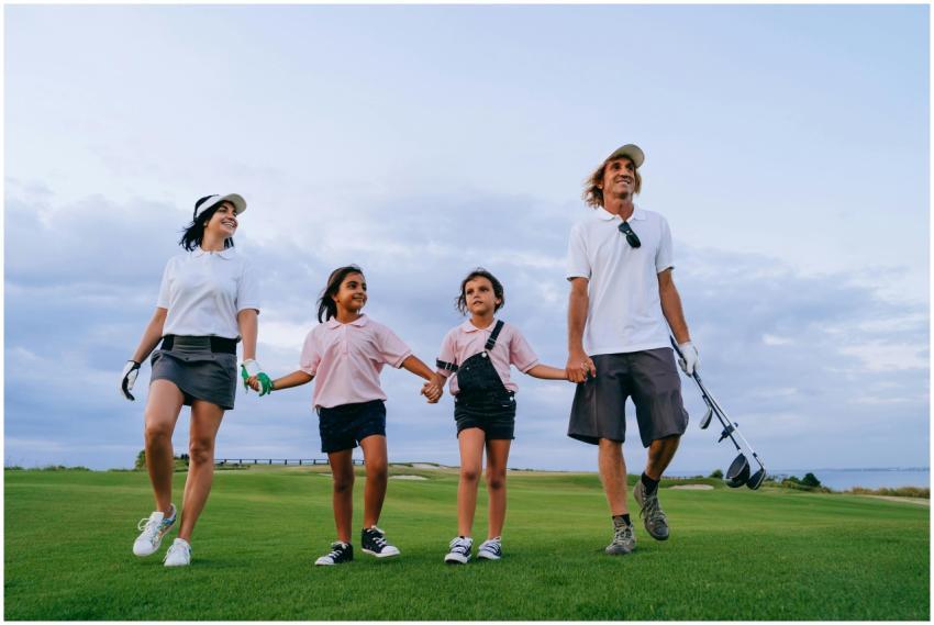 Happy family walking on a golf course together, en