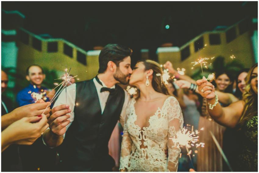 Bride and groom share a romantic kiss surrounded b