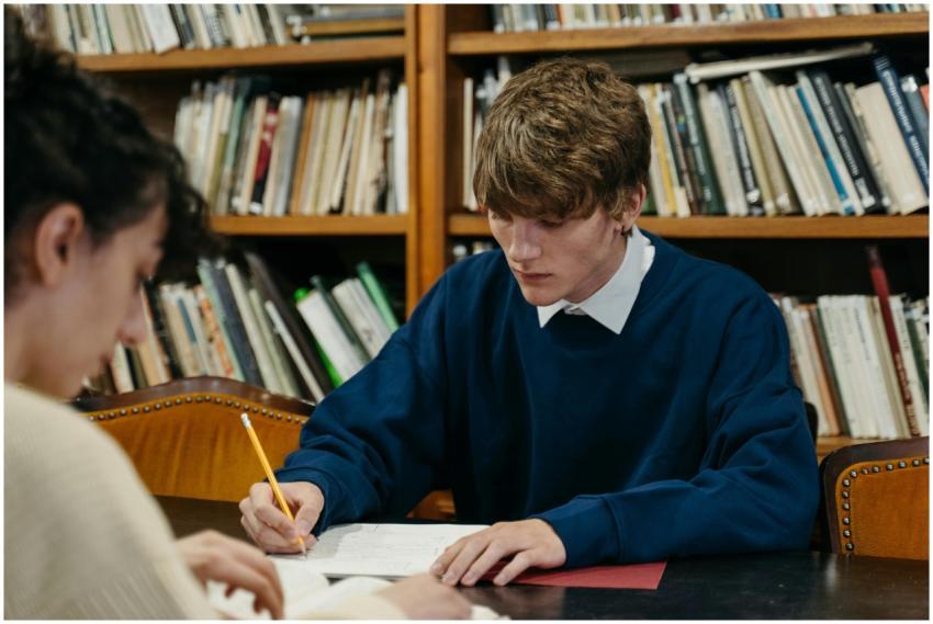 Two students studying intensely in a library envir