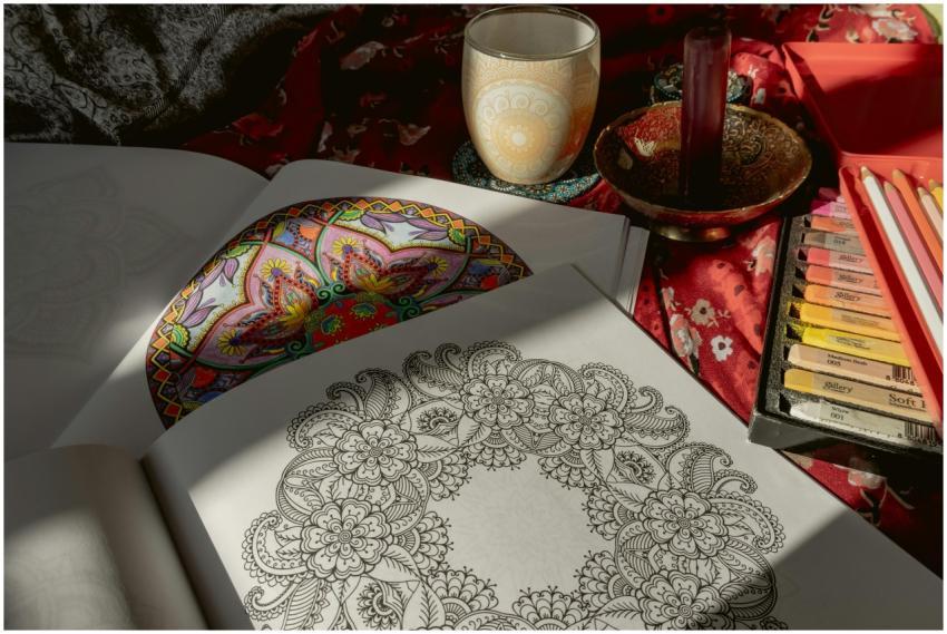 Colorful mandala coloring book with pencils and te