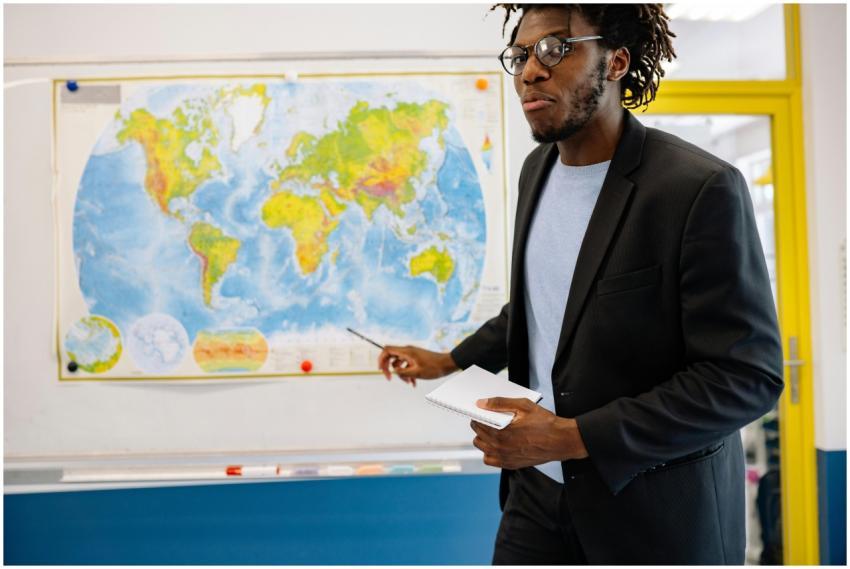 Confident teacher in a classroom explaining geogra