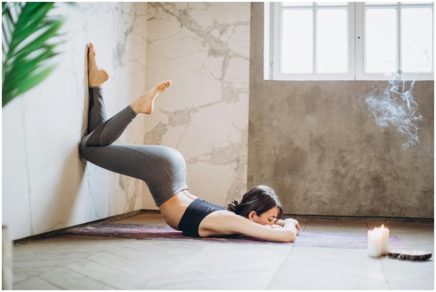 Woman practicing yoga against a wall in a peaceful