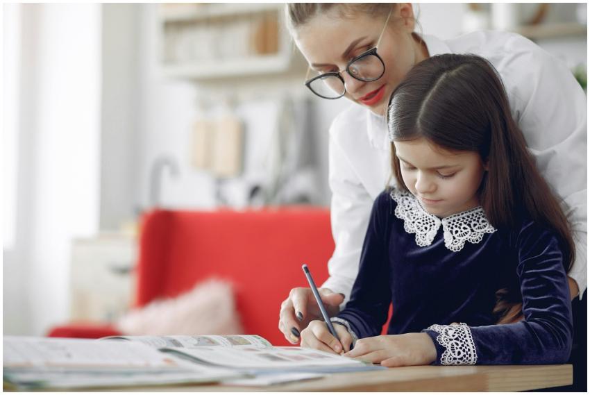 Young girl in casual clothes sitting at table and
