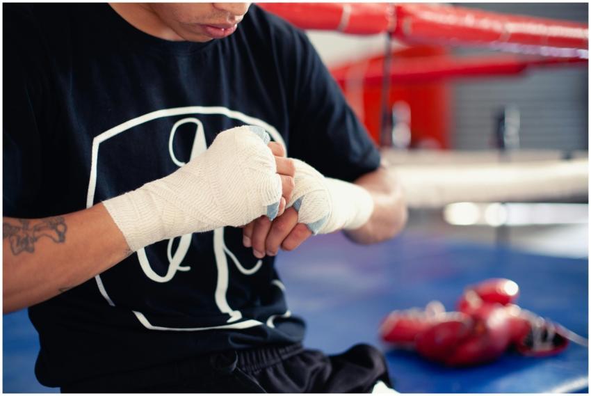 A boxer wrapping hands for training in a vibrant g