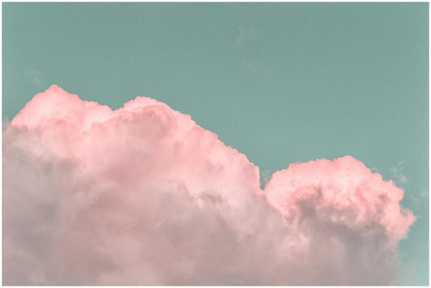 Pastel pink clouds in a clear blue sky create a se