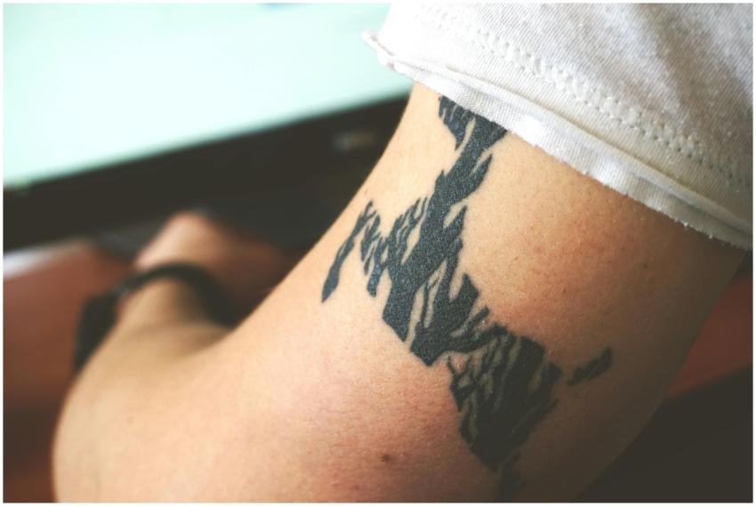 Detailed close-up of an abstract black arm tattoo