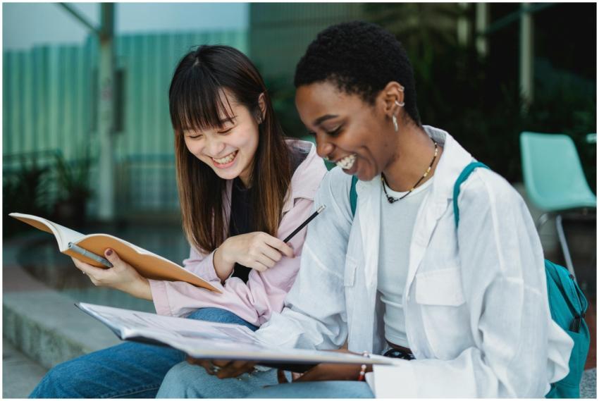 Smiling young multiethnic women sitting outdoors w
