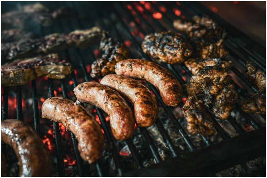 Close-up of sausages and meats roasting on a charc