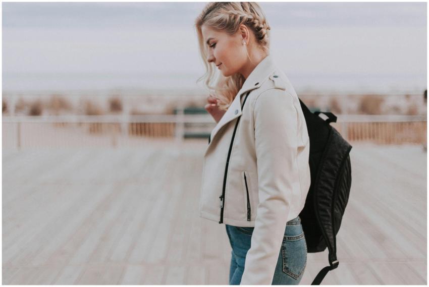 A young woman in a leather jacket walking on a boa