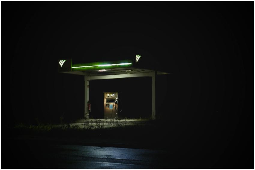 Isolated gas station glowing at night against a da