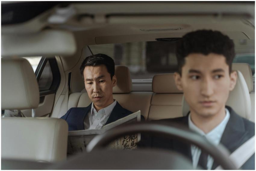 Elegant Asian businessman reading a newspaper insi