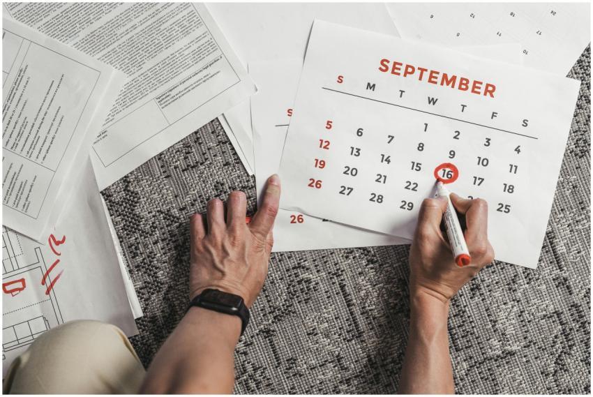 Hands holding a calendar with September dates enci