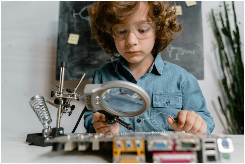 Child using tools like magnifying glass and solder