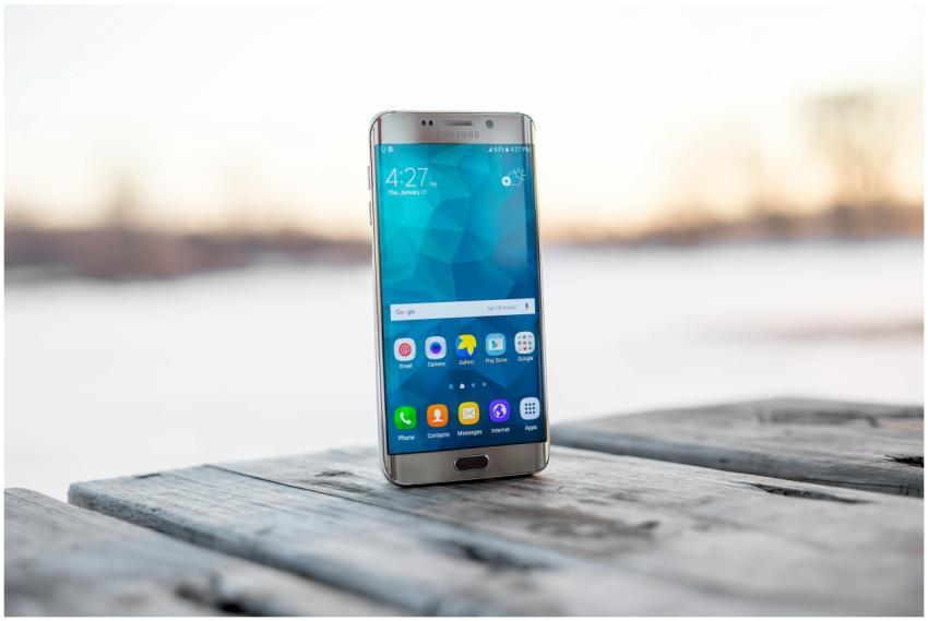 Samsung smartphone placed on a wooden surface outd