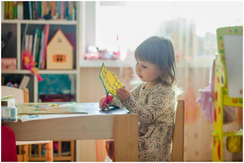 A young girl in a bright classroom engaged in a cr