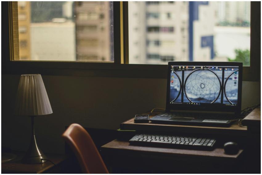 A tranquil home office setup with a laptop, lamp,