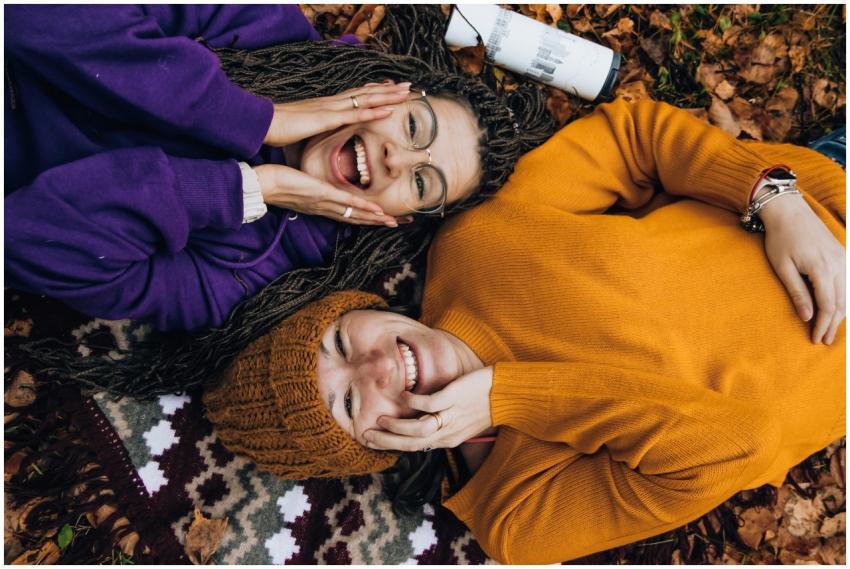 Two friends smiling, enjoying fall colors while ly