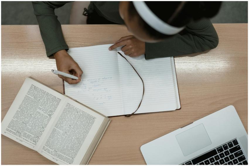 Top view of a person studying with an open book an
