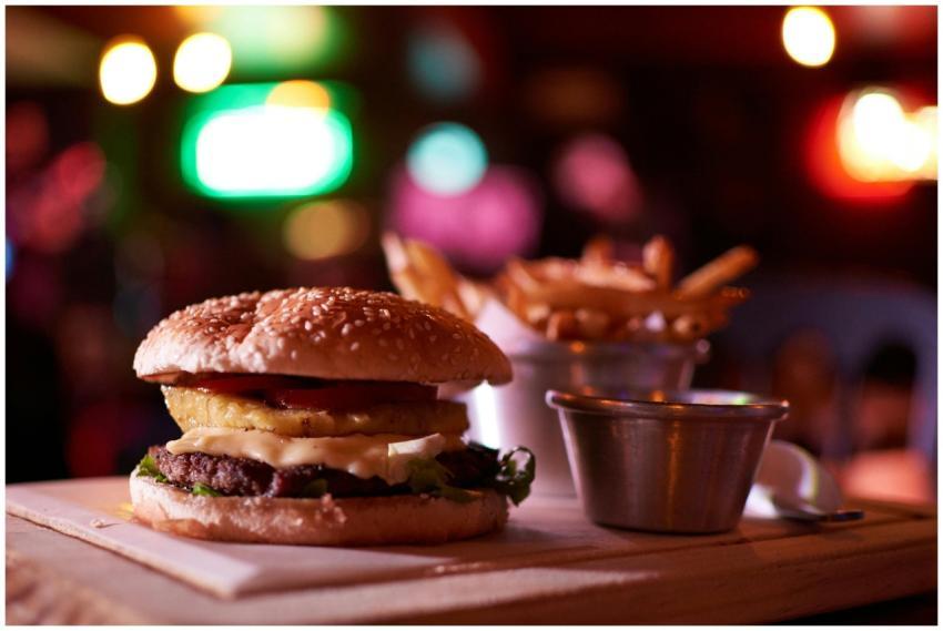 Delicious cheeseburger with pineapple and fries in