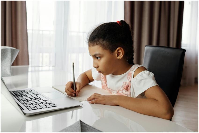 Young girl intensely focused on online learning at