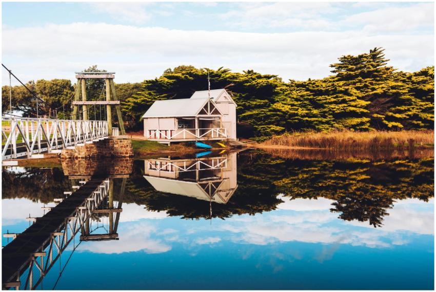 Scenic view of a boathouse and bridge reflecting i