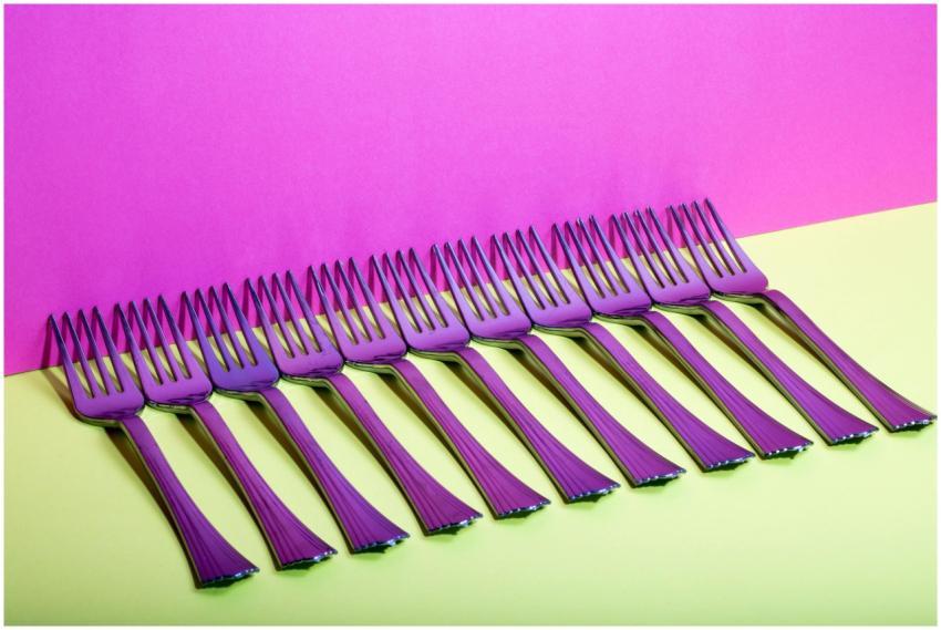 Artistic row of forks with colorful reflections ag