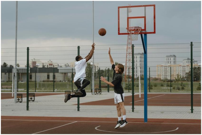 Two men playing an intense game of basketball outd