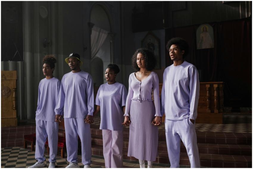 Five singers in matching lavender attire perform i