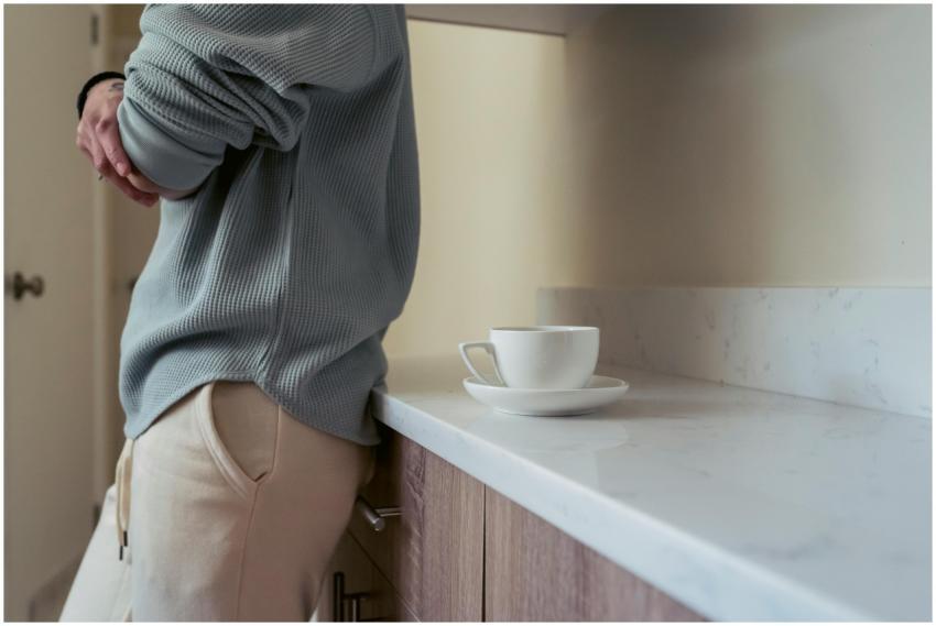 A person leans on a kitchen counter with a cozy mo