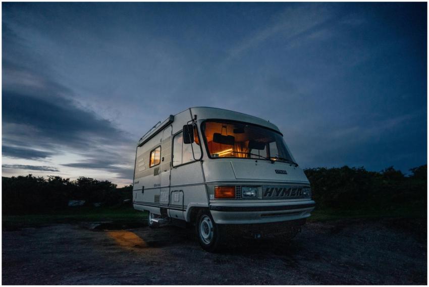 Camper van parked in rural area at twilight, glowi
