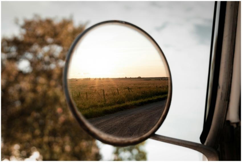 A serene countryside landscape reflected in a car'