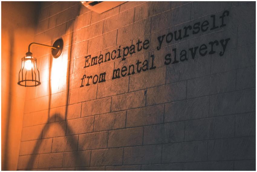 A wall lamp casts a warm glow on an inspirational