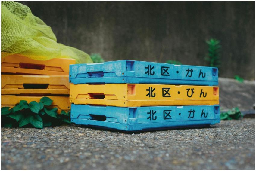 Vibrantly colored crates stacked on a street in To