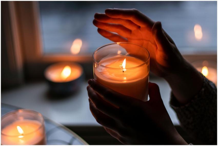 Warm candlelit ambiance with hands gently holding