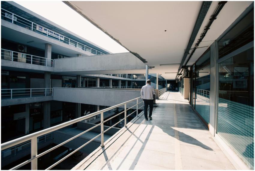 A shopper walks through a modern, sunlit shopping
