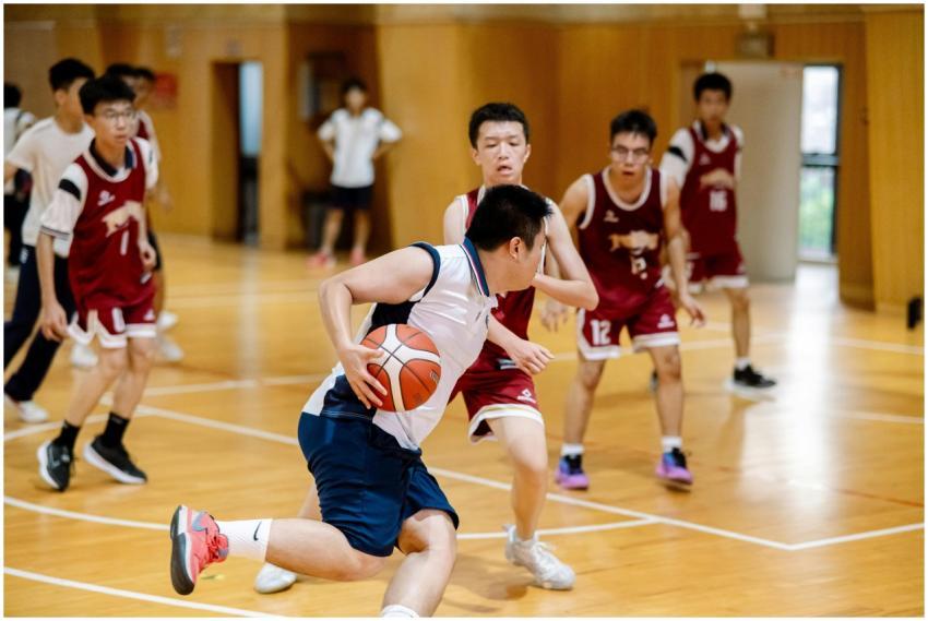 Teenagers playing basketball in an indoor court, s