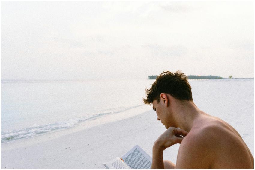 A man enjoys reading a book on a serene Maldives b