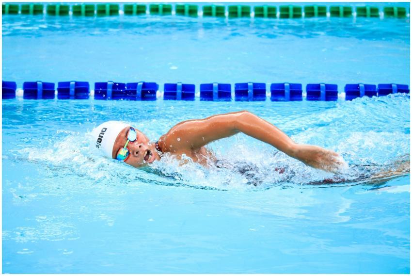 A swimmer energetically performs a freestyle strok
