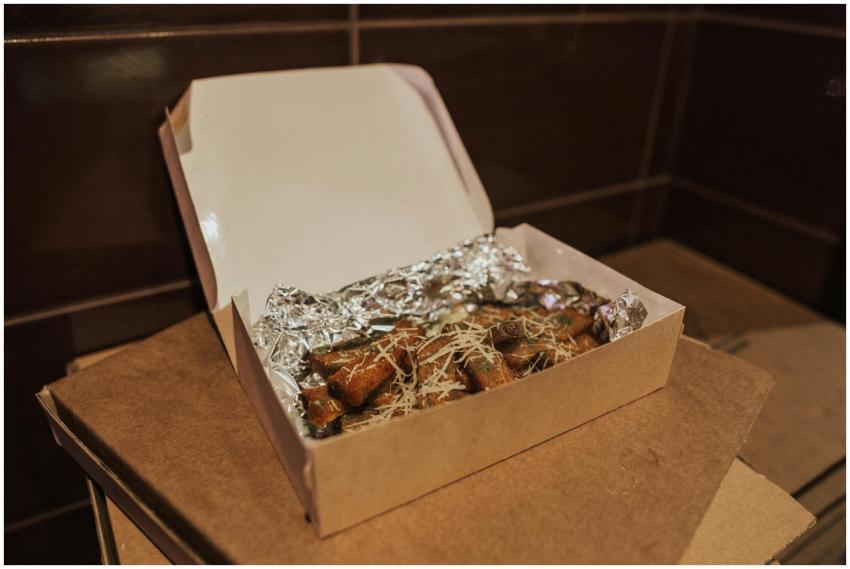 Delicious fried food in an open box lined with foi