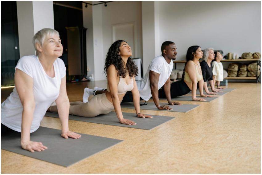 A group of adults performing yoga poses on mats in