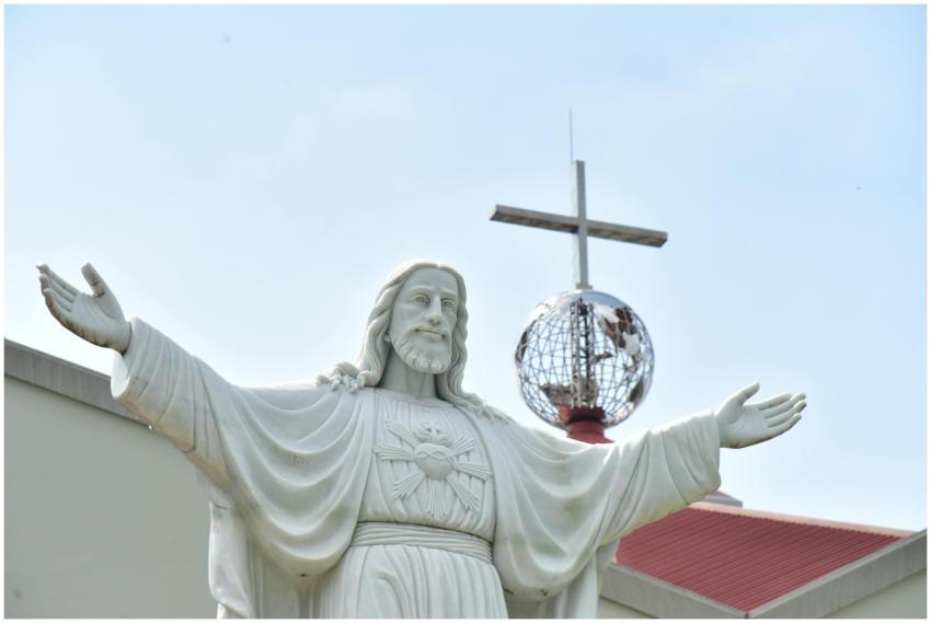 A white statue of Jesus Christ with outstretched a