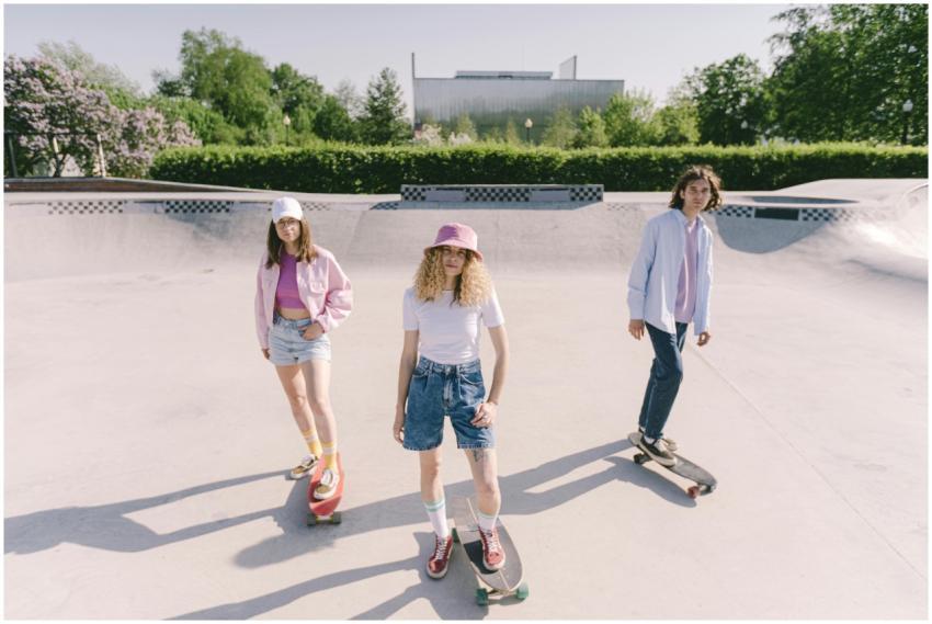 Three young adults skateboarding in an outdoor ska