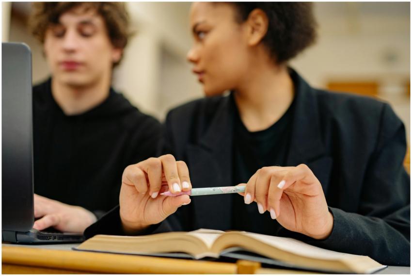 Two students working together on a project in a li